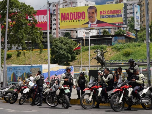 police officers stand near a hoarding with an image of venezuela s president nicolas maduro in caracas venezuela july 31 2024 photo reuters police officers stand near a hoarding with an image of venezuela s president nicolas maduro in caracas venezuela july 31 2024 photo reuters